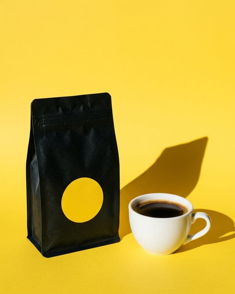 Brightside ad, a fictional coffee brand: a black coffee bag and a cup on a yellow background